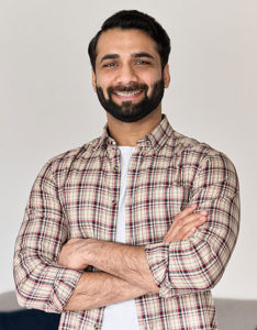 smiling bearded man with arms folded